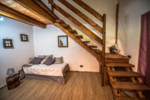 a bedroom with a bed and a wooden staircase at Cascina Lunguria in Francavilla Bisio