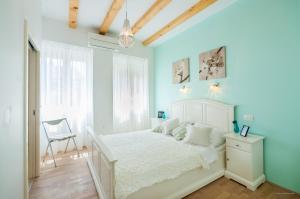 a bedroom with a white bed and a chair at Aldo Apartments Center in Zadar