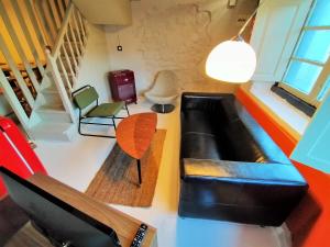 een woonkamer met een zwarte leren bank en stoelen bij Loft Borines in Borines