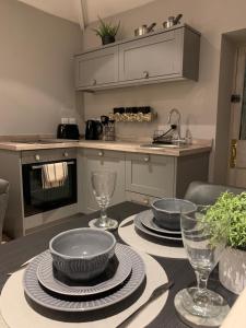 a kitchen with a table with plates and glasses on it at The Carriage House in Matlock
