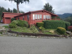 a red house with bushes in front of it at Whaleshead Beach Resort in Brookings