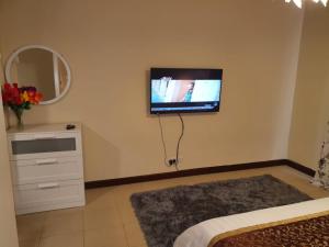 إطلالة بحرية عوائل فقط KAEC Star Sea View في King Abdullah Economic City: غرفة نوم مع تلفزيون بشاشة مسطحة على الحائط