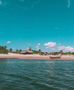 einen Strand mit einem kleinen Boot im Wasser in der Unterkunft Casa Gael (Gisele & Lucimar) in Atins