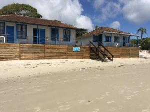 a house on the beach with a wooden fence at Dona Quinota in Ilha do Mel