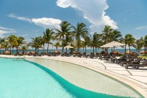 a resort swimming pool with chairs and palm trees at Hyatt Ziva Riviera Cancun All-Inclusive in Puerto Morelos