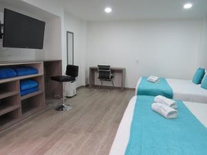 Habitación de hotel con 2 camas y TV de pantalla plana. en Hotel Los Cristales, en Santa Rosa de Cabal