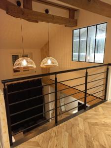 a staircase in a house with two chandeliers at T3 proche agen, toutes commodités in Foulayronnes