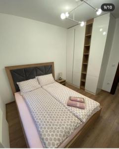 a bedroom with a large bed with a pink towel on it at Apartman Pavle in Zlatibor