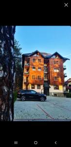 a black car parked in front of a building at Apartman Pavle in Zlatibor