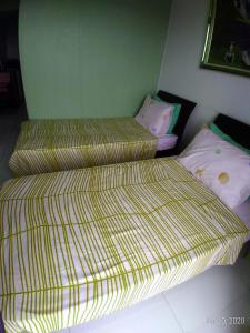 twee bedden naast elkaar in een kamer bij Rm Staycation TaalView Smdc in Tagaytay