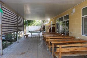 a row of wooden benches in front of a building at Beylagan Naftalan Hotel in Beylǝqan