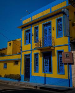 Edificio amarillo y azul con balcón en Pousada Aruans Casarão, en Bragança