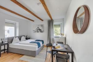 a bedroom with a bed and a table and a mirror at Innsbruck City Chalet in Innsbruck