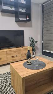a bottle of wine and two glasses on a table at Apartman Maslacak in Divčibare