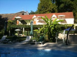 - une piscine avec des chaises et des parasols à côté d'une maison dans l'établissement Château de Challanges, à Beaune