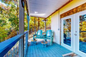 a porch with two chairs and a table on it at Hellava View in Sevierville