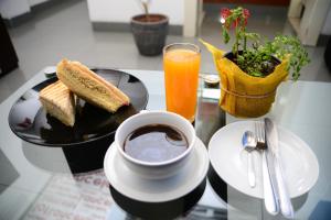 una mesa con un plato de tostadas y una taza de café en Lancelot Hostal, en Chiclayo
