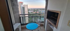 a room with a blue chair and a large window at Departamento 1 dormitorio en complejo con amenities - Córdoba Ciudad in Cordoba