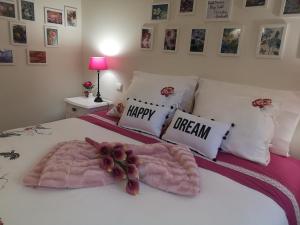 a bed with a pink blanket and a happy dream pillow at Architect House in Porto