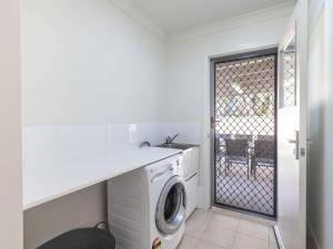a laundry room with a washing machine and a gate at 15 Oasis Close Soldiers Point in Soldiers Point