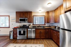 uma cozinha com armários de madeira e electrodomésticos de aço inoxidável em Truckee Mountain Retreat em Truckee