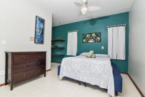 1 dormitorio con cama y pared azul en Residencial Rio Tavares, en Florianópolis