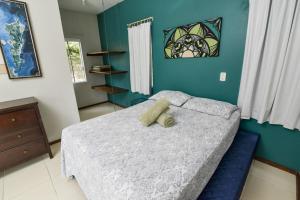 a bedroom with a bed with a teddy bear on it at Residencial Rio Tavares in Florianópolis