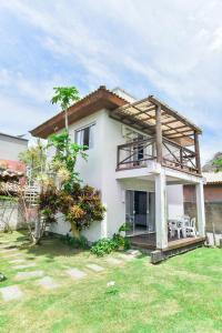 a white house with a balcony and a yard at Residencial Rio Tavares in Florianópolis