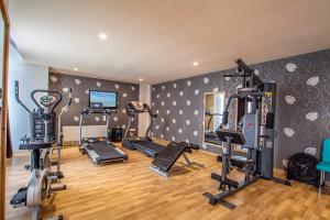 a gym with several tread machines in a room at Noble Hotel in Erbil