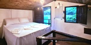 Cette chambre comprend un lit avec une table et une fenêtre. dans l'établissement Casa do Mar Caraíva, à Caraíva