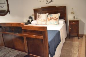 a bedroom with a bed with a wooden bed frame at O Prado do Forno in O Barco de Valdeorras +49 photos