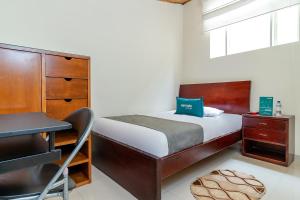 ボゴタにあるAyenda Nabusimakeのベッドルーム1室(ベッド1台、デスク、椅子付)