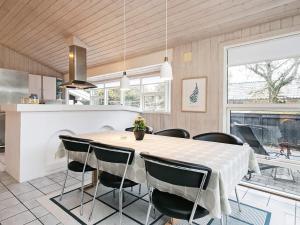 a kitchen and dining room with a table and chairs at 8 person holiday home in Bl vand in Blåvand