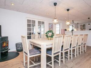 a dining room with a table and chairs and a stove at Holiday home Blåvand CCCVIII in Blåvand