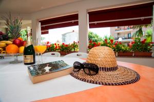 a hat and a book and a bottle of wine on a table at Villa Fontana in Sukošan