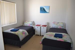a bedroom with two beds and a window at Christies Seahorse Holiday Townhouses in Port Noarlunga