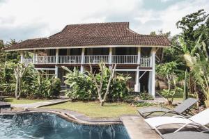 una casa con piscina di fronte a una casa di Anggrek Putih Homestay & cooking class a Senggigi