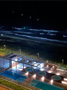 einen Blick über den Pool in der Nacht in der Unterkunft BarraVilha Resort Vista Mar e Pé na Areia in Barra Velha