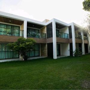 a large building with a green lawn in front of it at Iloa Residence1 in Barra de São Miguel