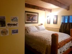 a bedroom with a bed and pictures on the wall at Big Mountain Cedar Cabin in Whitefish