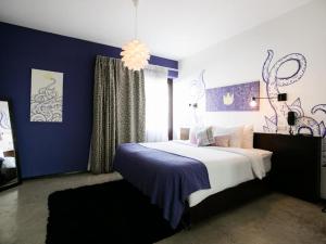 a bedroom with a bed with a blue wall at Tantalo Hotel - Kitchen - Roofbar in Panama City