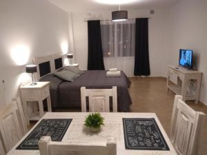 1 dormitorio con 1 cama, mesa y sillas en Apart jujuy Suite Premium en San Salvador de Jujuy