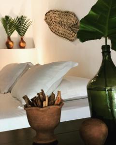 ピパにあるKûara Pipaのベッドルーム1室(ベッド1台付)、花瓶1本(植物付)