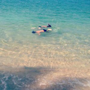 two people swimming in the water in the ocean at Jasmine & Tea House in Mae Nam