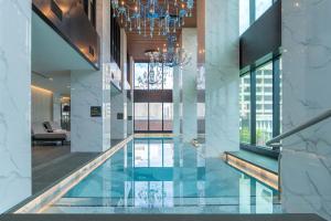 a swimming pool in a building with a chandelier at Sofitel Adelaide in Adelaide