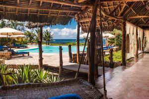 um resort com uma piscina com cadeiras e guarda-sóis em The Charming Lonno Lodge Watamu em Watamu