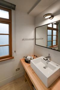 a bathroom with a white sink and a mirror at Humanlive in Tainan