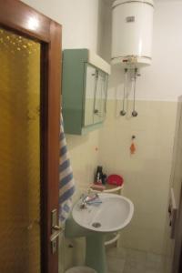 een badkamer met een witte wastafel en een spiegel bij Rooms Jakirusa in Brela