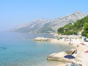 een strand met een groep mensen op het water bij Rooms Jakirusa in Brela