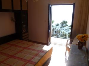 een kamer met een tafel met een vaas met bloemen erop bij Rooms Jakirusa in Brela